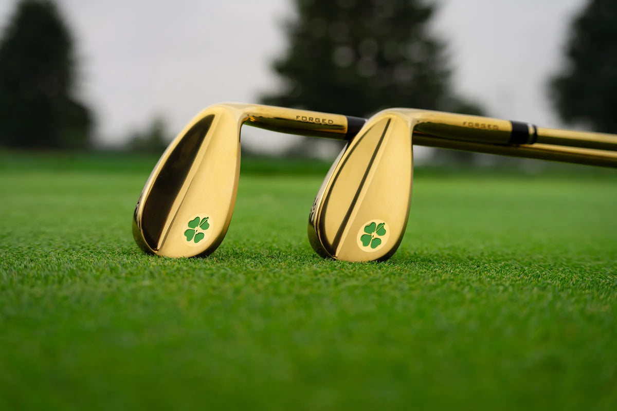 Two gold Carver wedges resting on the fairway